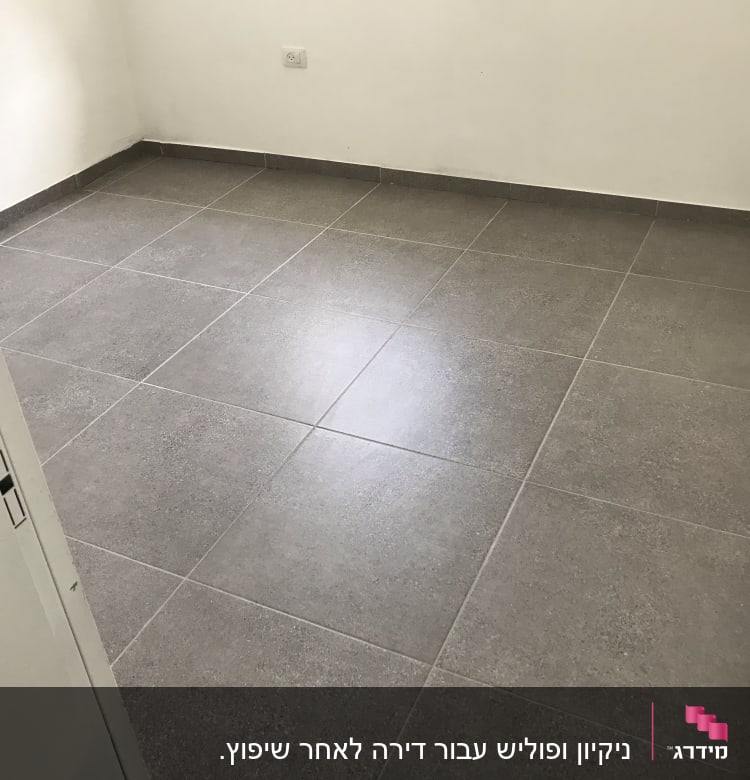 רצפה נקייה עם אריחים אפורים בחדר ריק
